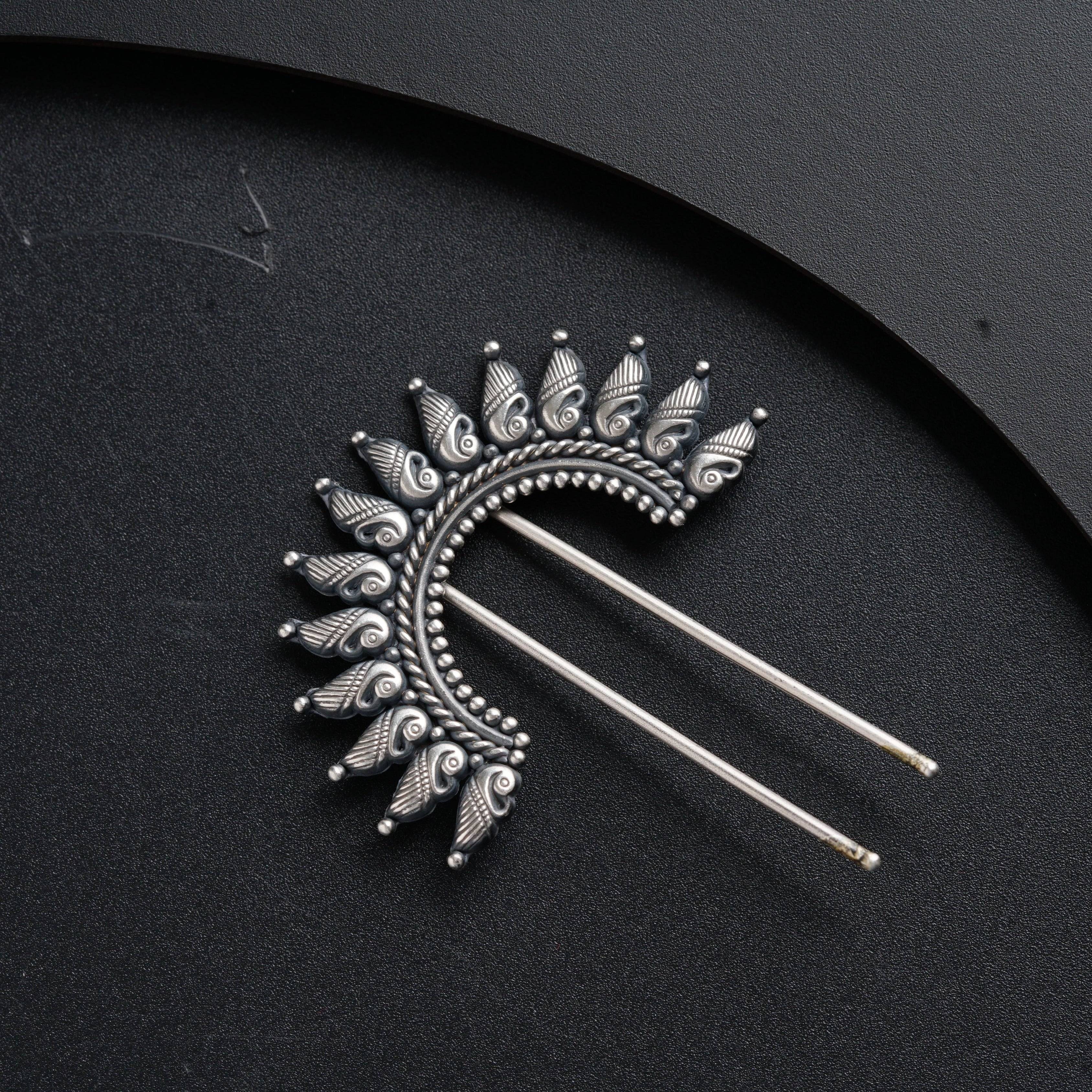 a pair of hair pins sitting on top of a black surface