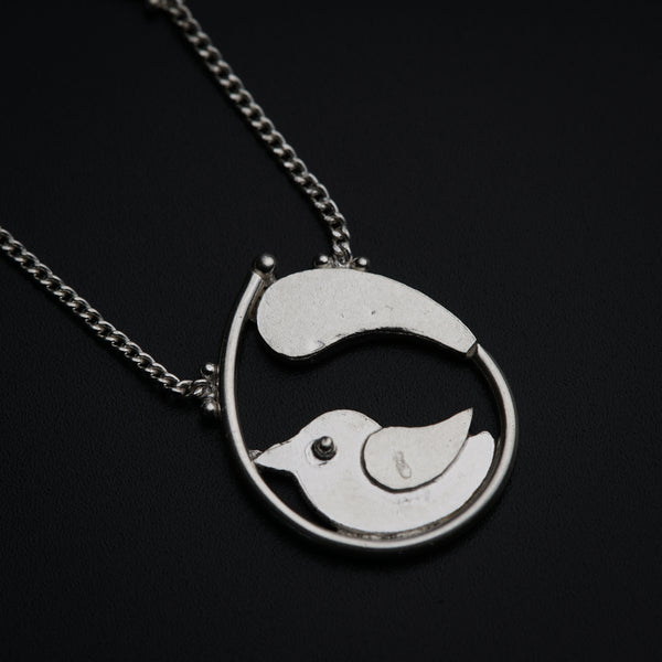 a silver necklace with a bird on it