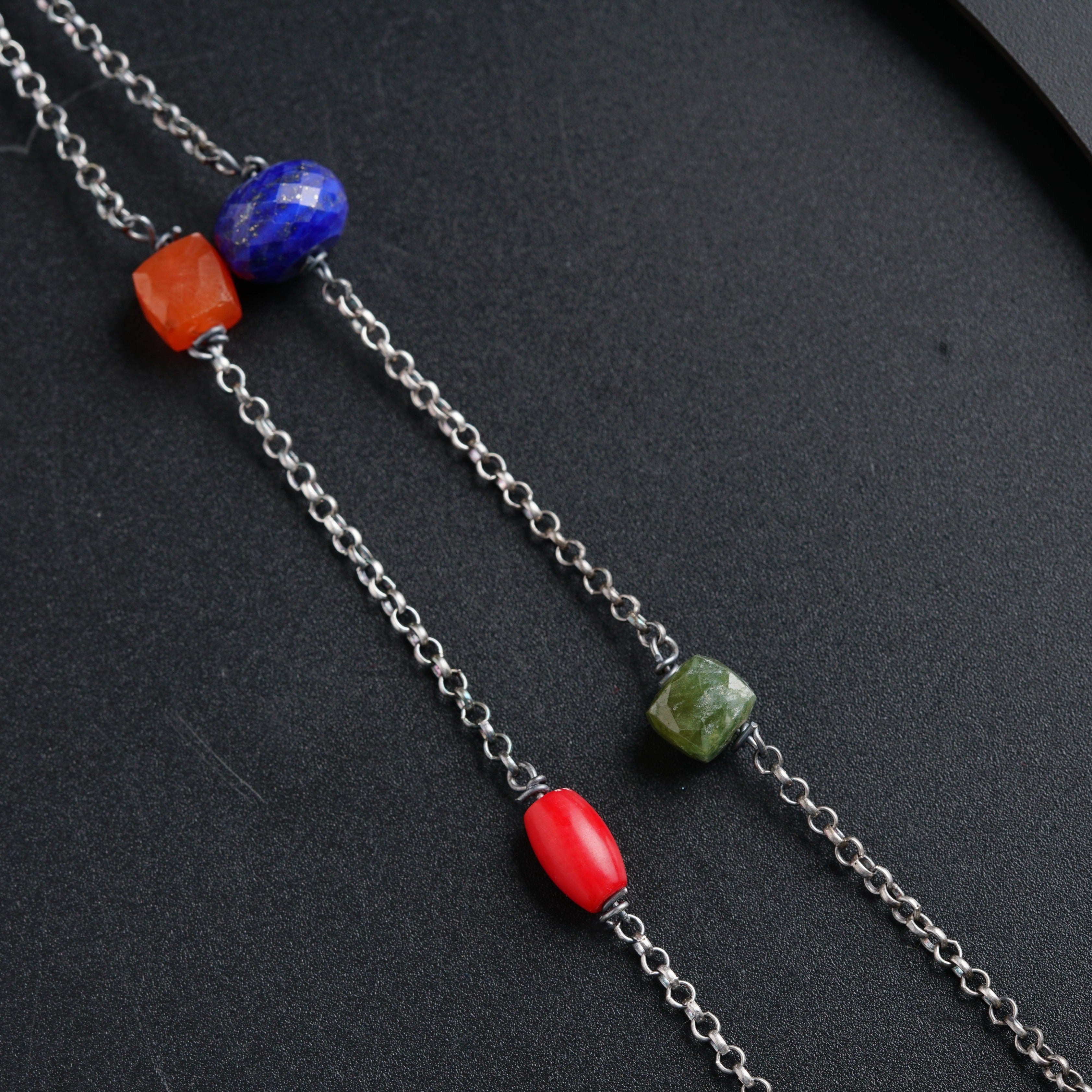 a close up of three different colored beads on a chain
