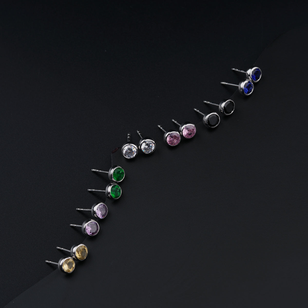 a row of different colored stones on a black surface