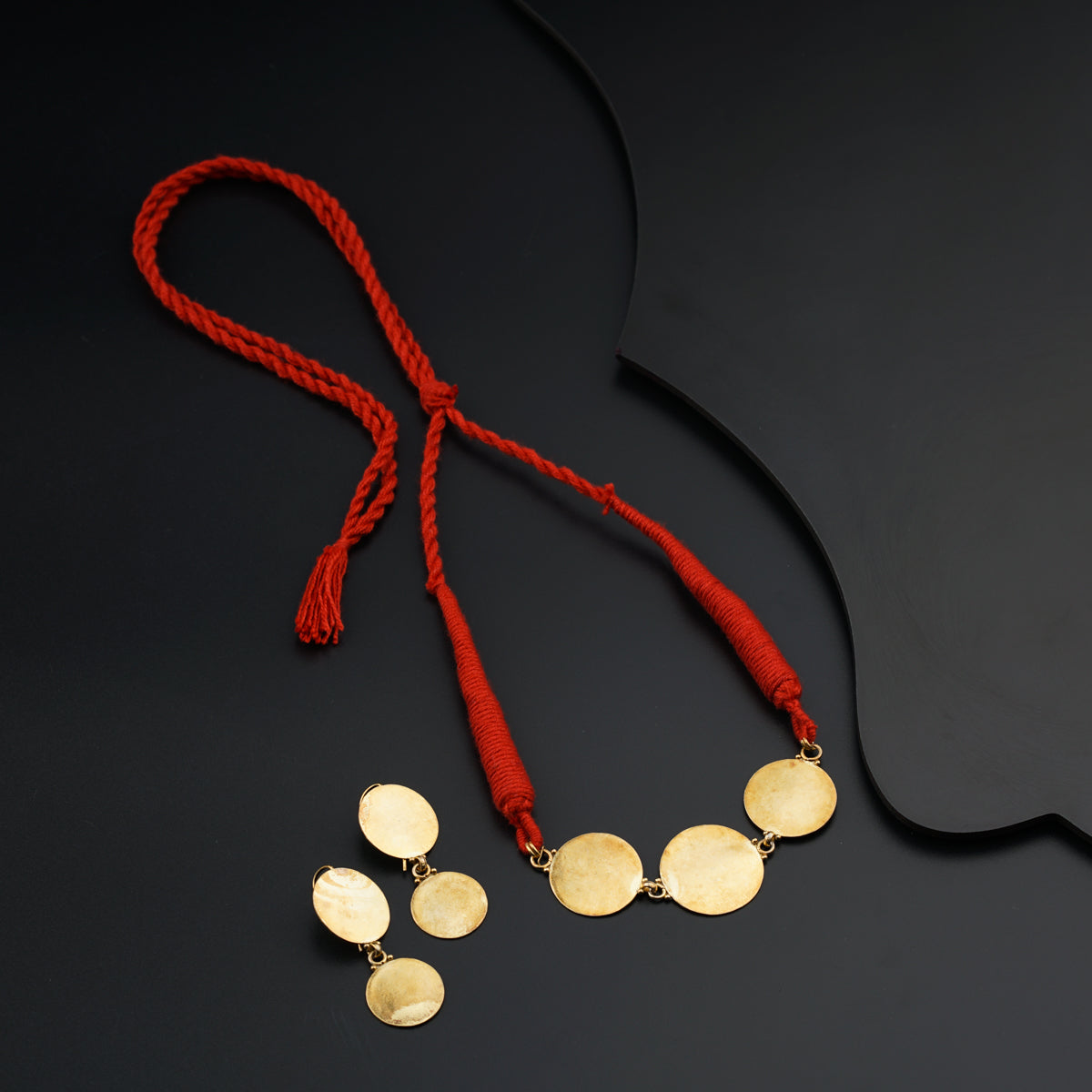 a red cord with three gold discs on it