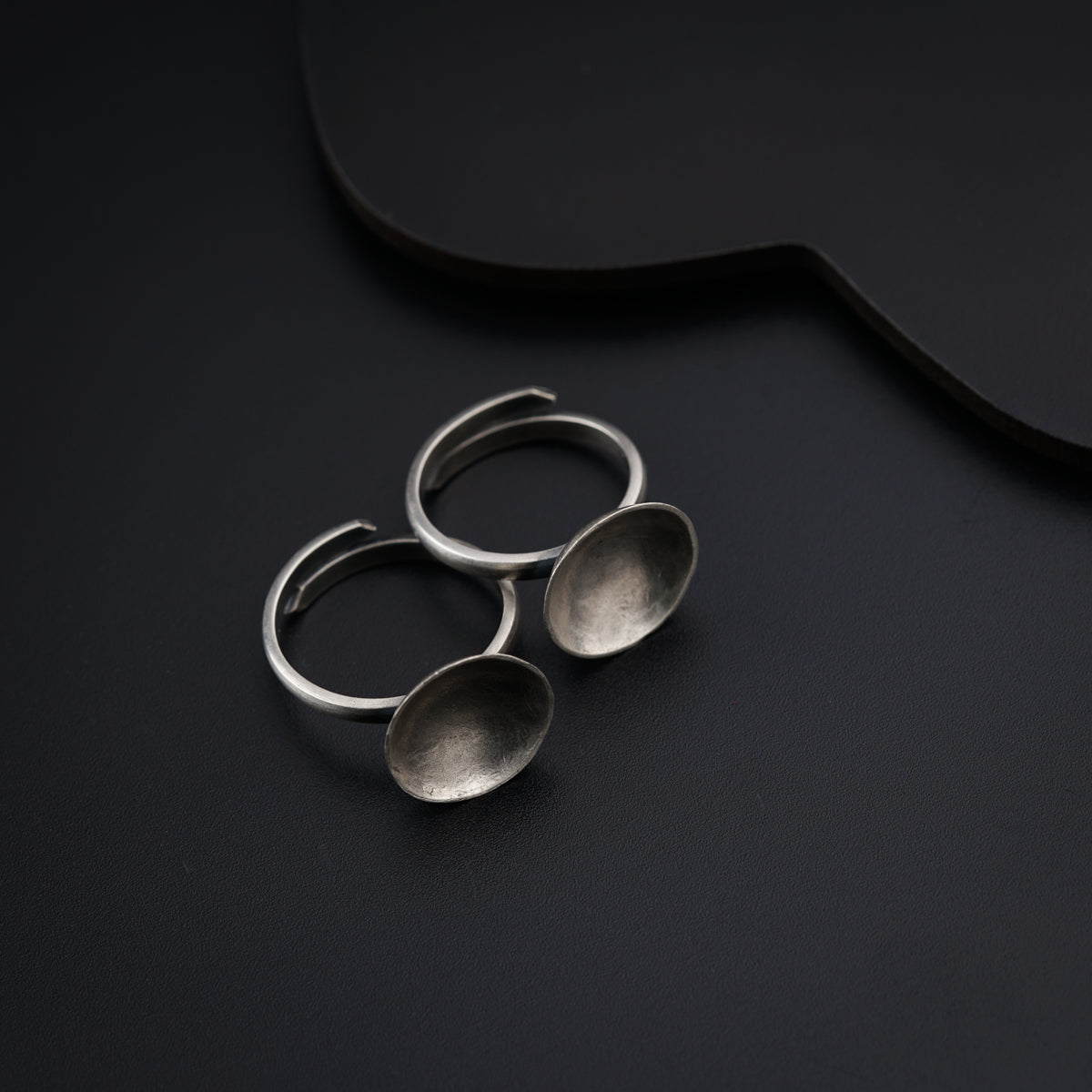 a pair of spoons sitting on top of a black table
