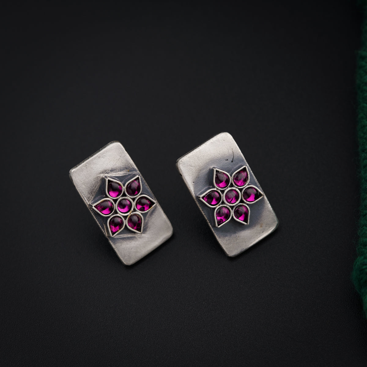 a pair of silver earrings with pink stones