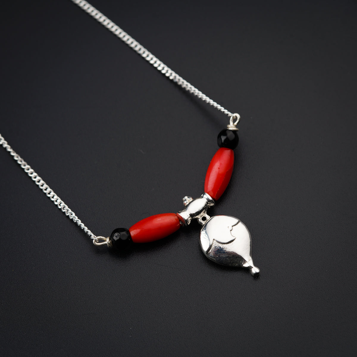 a red and silver necklace with a heart on it