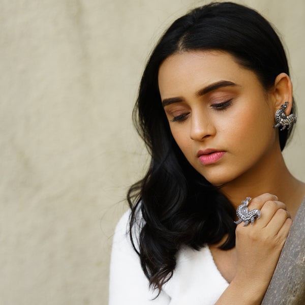 a woman wearing a white shirt and earrings