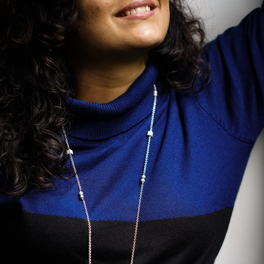 a woman wearing a blue shirt and a necklace