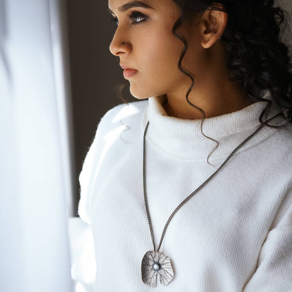 a woman wearing a white sweater and a necklace