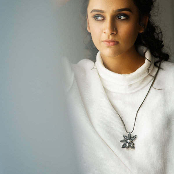 a woman wearing a white sweater and a necklace