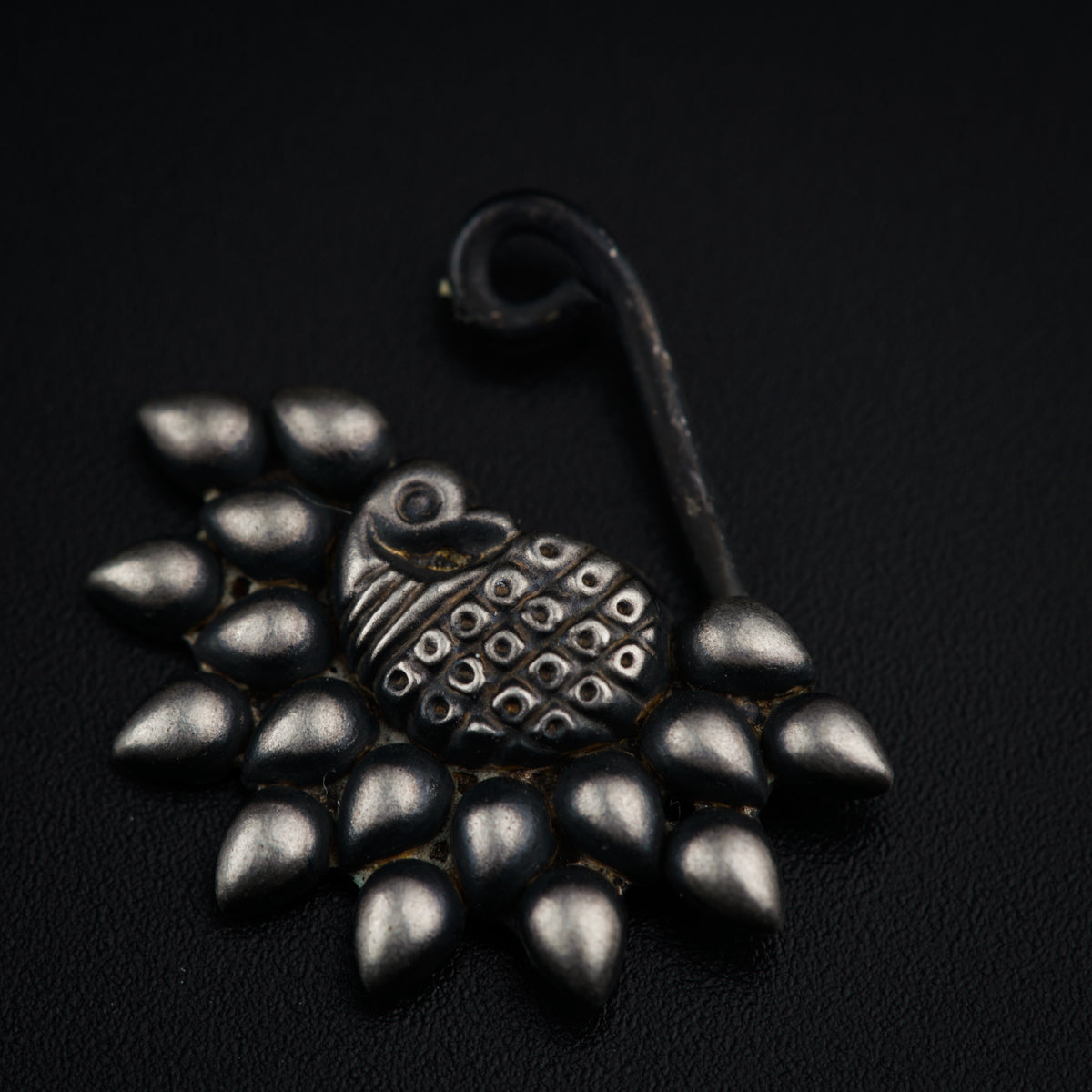 a black and silver brooch with lots of spikes