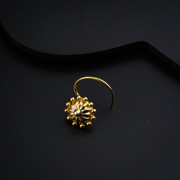 a pair of gold earrings on a black surface