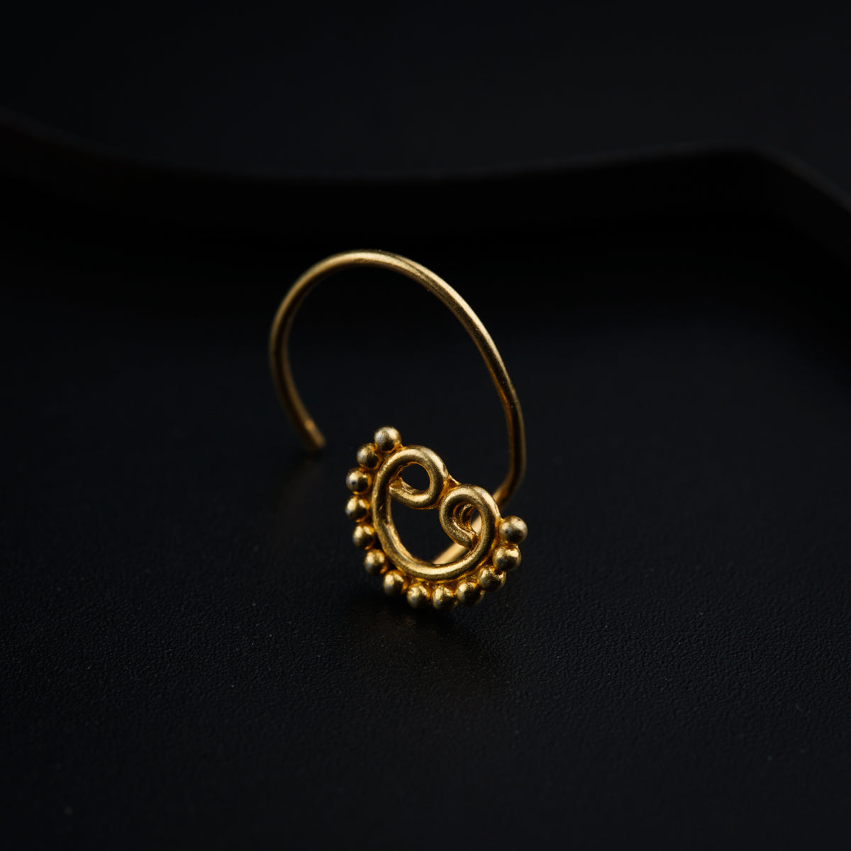 a gold nose ring with a smiley face on it
