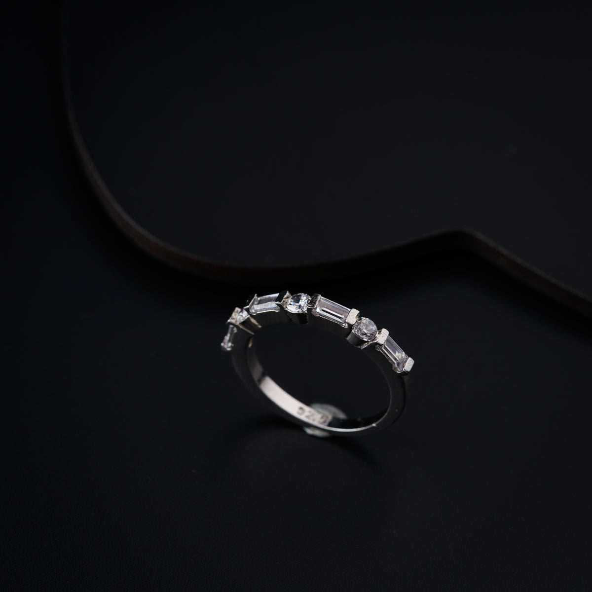 a diamond ring sitting on top of a black surface