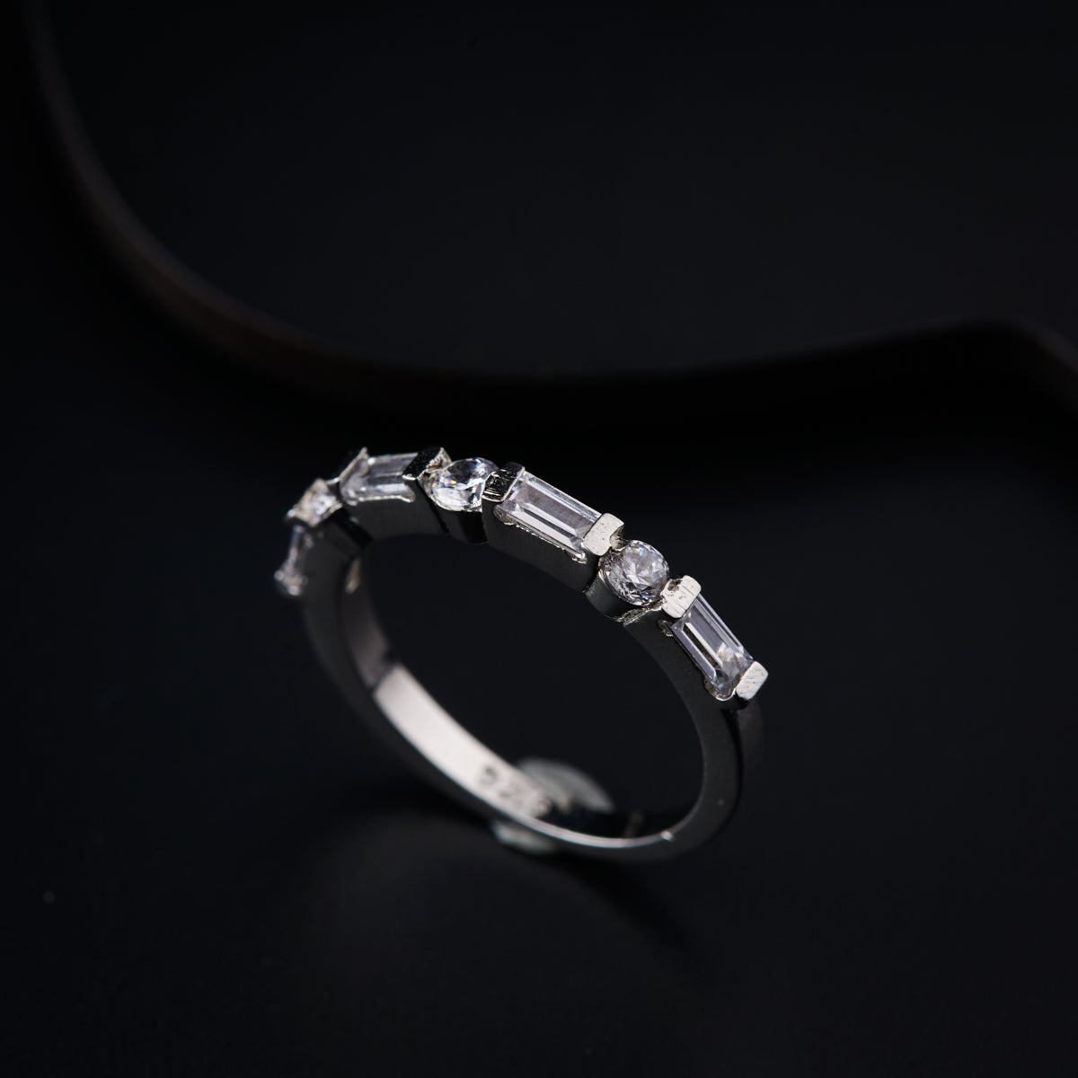 a diamond ring on a black surface