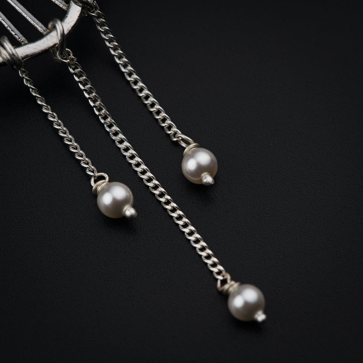 a close up of a pair of pearls on a chain
