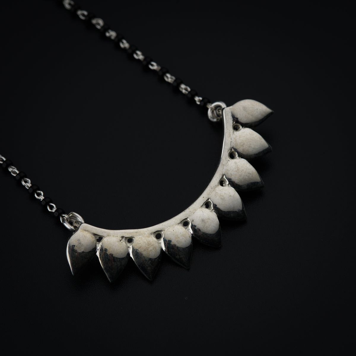 a close up of a necklace on a black background