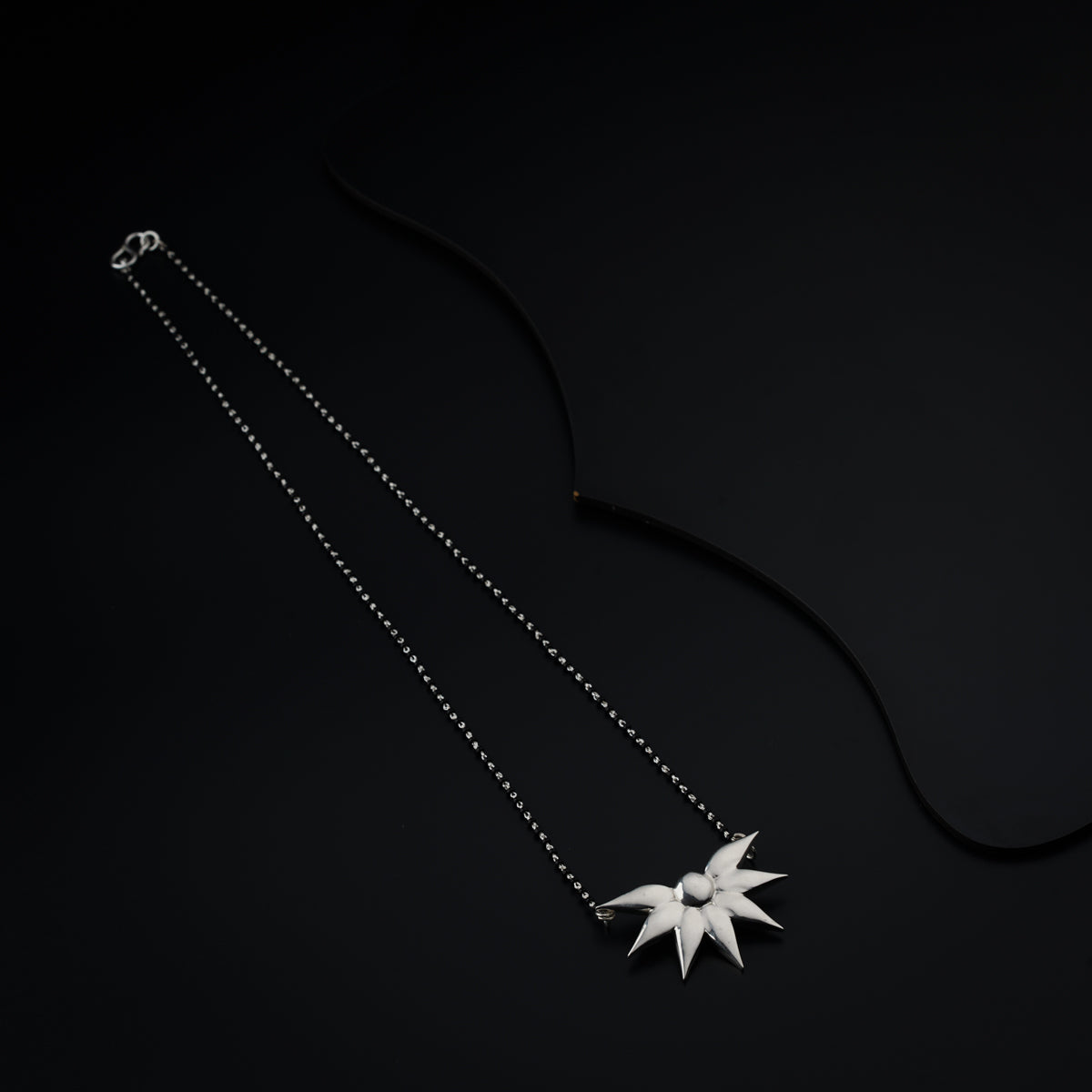 a necklace with a star on a black background