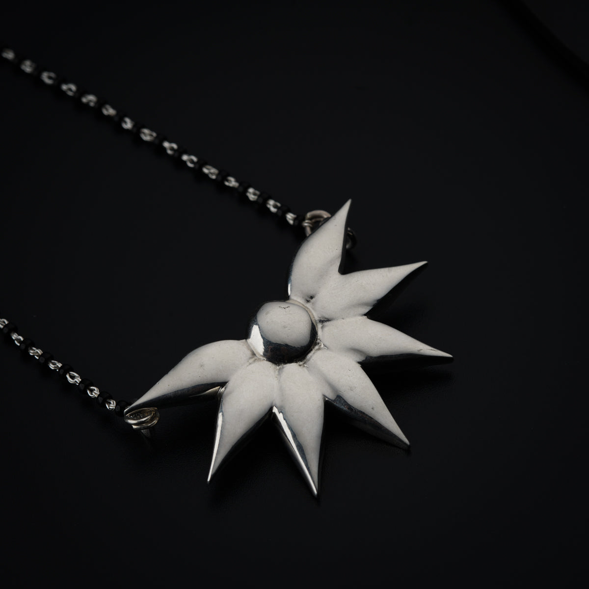 a silver necklace with a star design on it