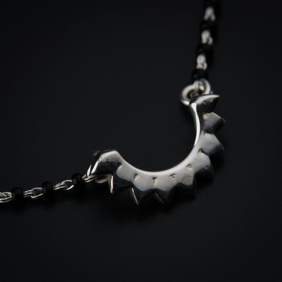 a black and silver necklace with spikes on it