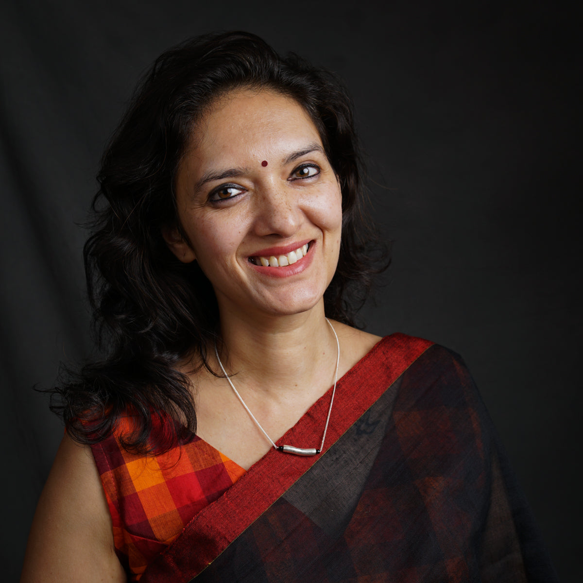 a woman in a sari smiling at the camera