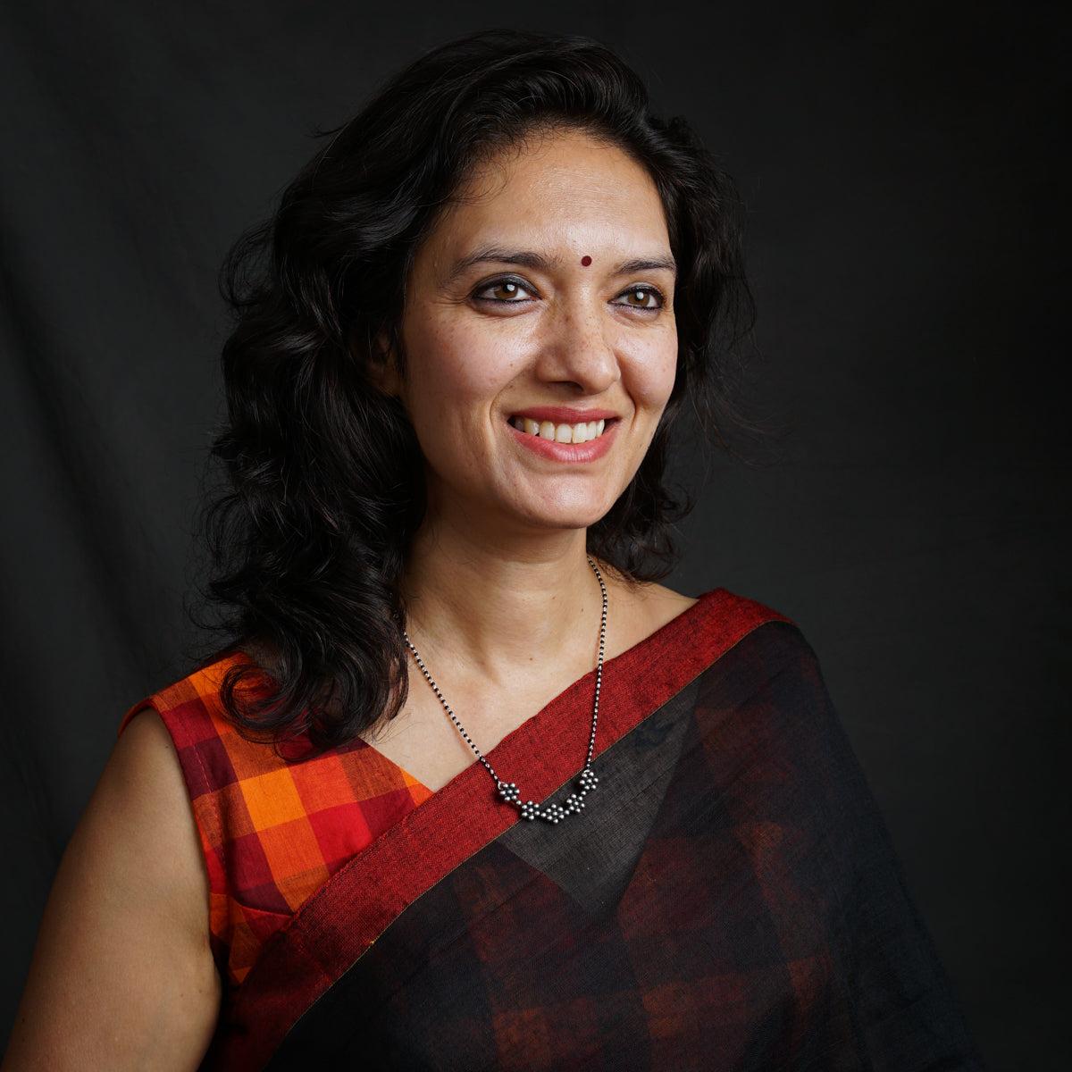 a woman in a red and black sari