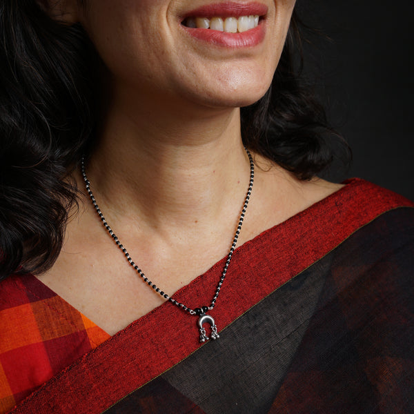 a woman wearing a necklace with a cross on it