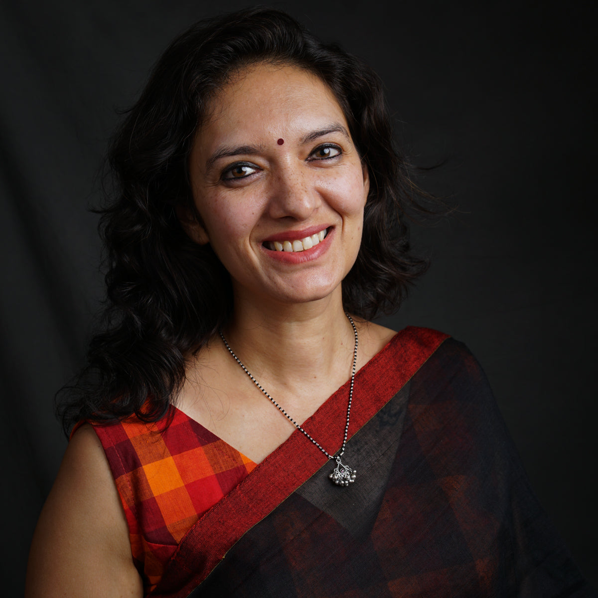 a woman wearing a red and black sari