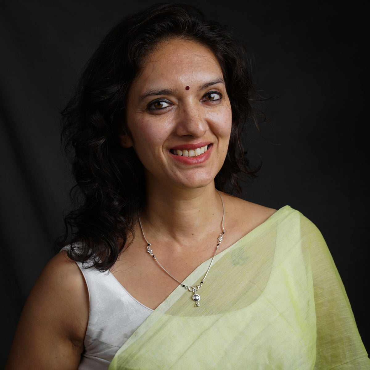 a woman in a sari smiling for the camera