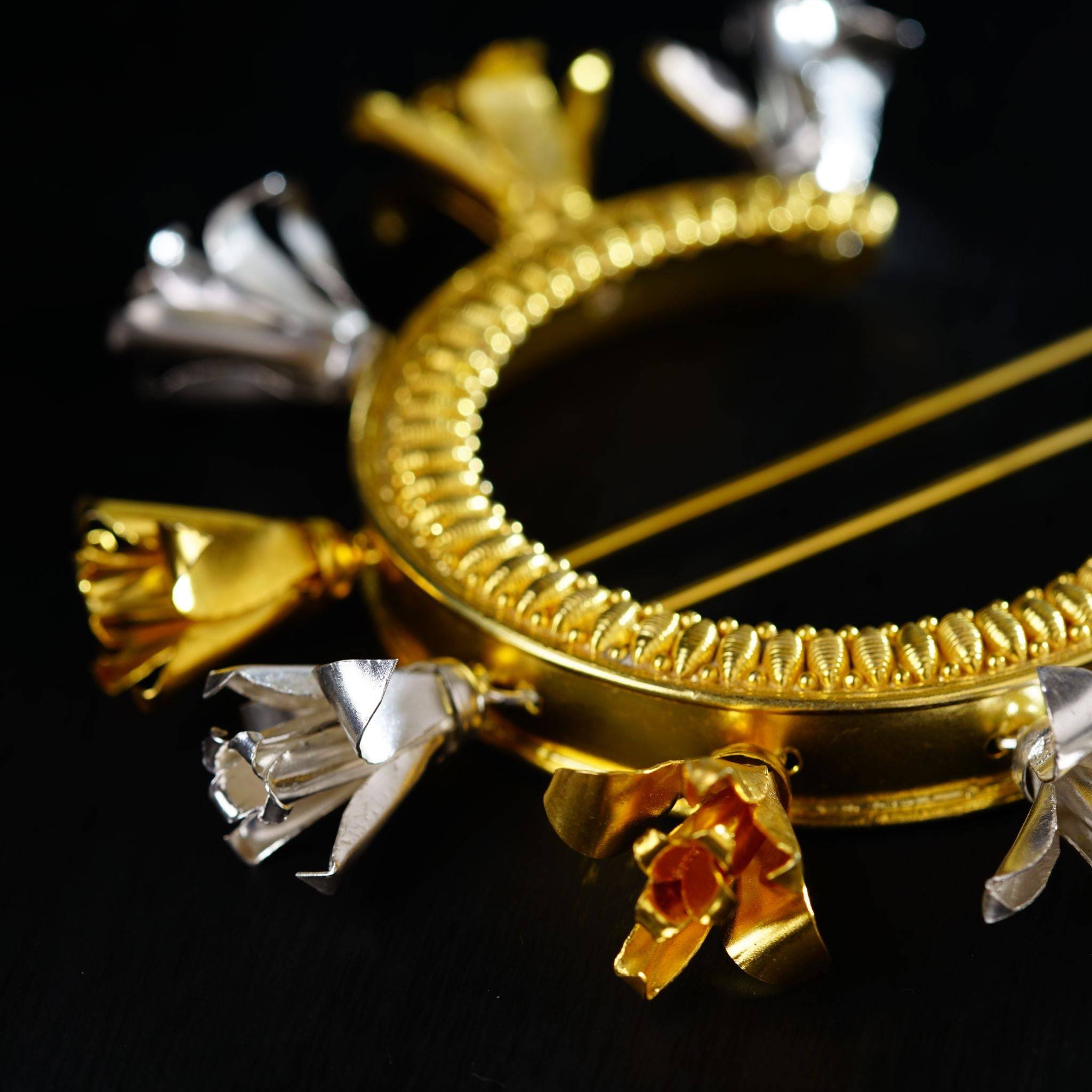 a close up of a gold bow brooch