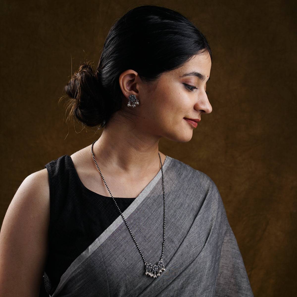 a woman wearing a black and grey sari