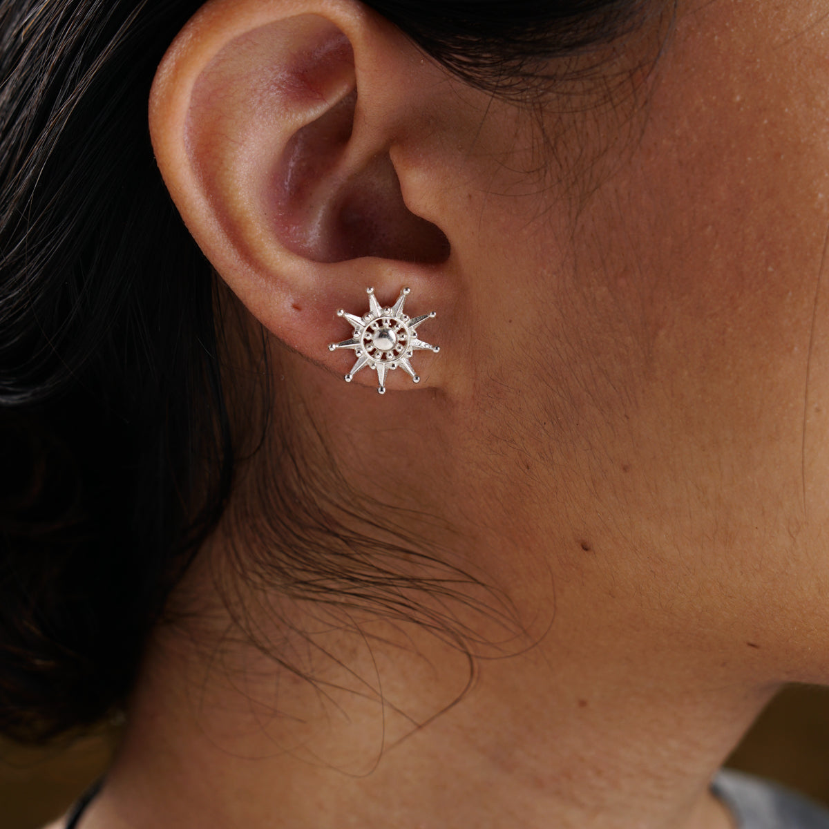 a close up of a person wearing a pair of earrings