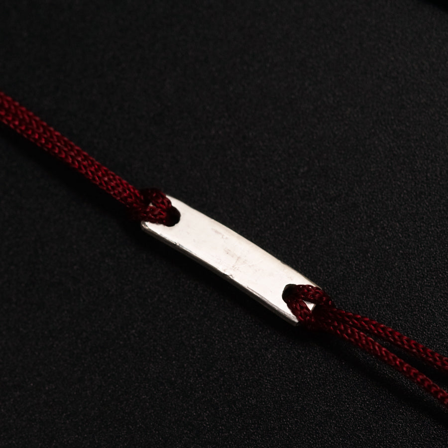 a pair of scissors with a red string on a black surface