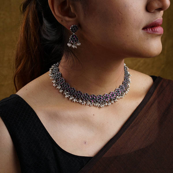 a close up of a woman wearing a necklace and earrings