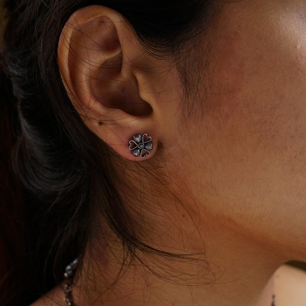 a close up of a person wearing a pair of earrings