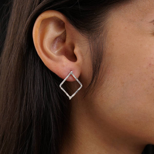 a close up of a person wearing a pair of earrings