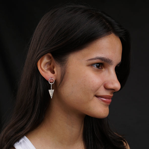 a close up of a person wearing a pair of earrings