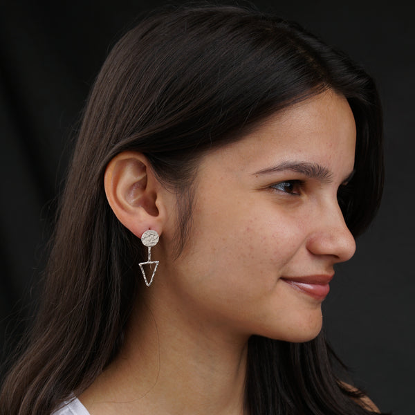 a close up of a person wearing a pair of earrings