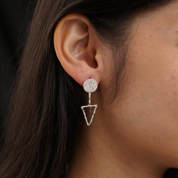 a close up of a person wearing a pair of earrings