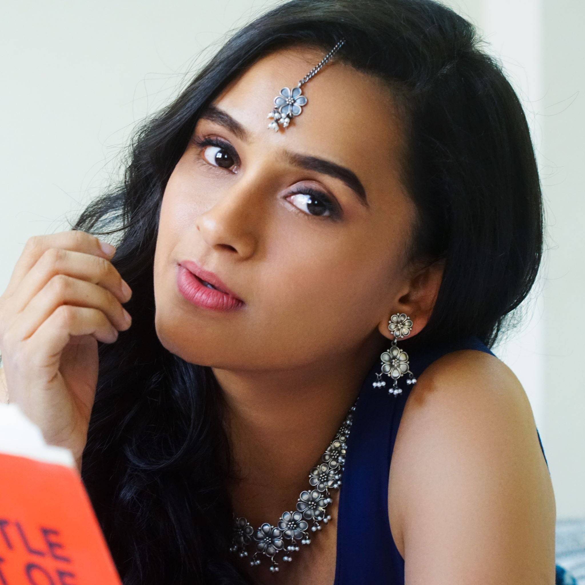 a woman in a blue dress is reading a book