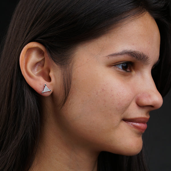 a close up of a person wearing a pair of earrings