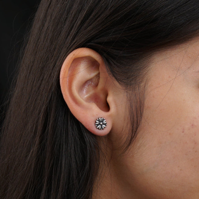 a close up of a person wearing a pair of earrings