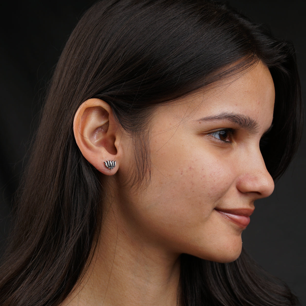 a close up of a person wearing a pair of earrings