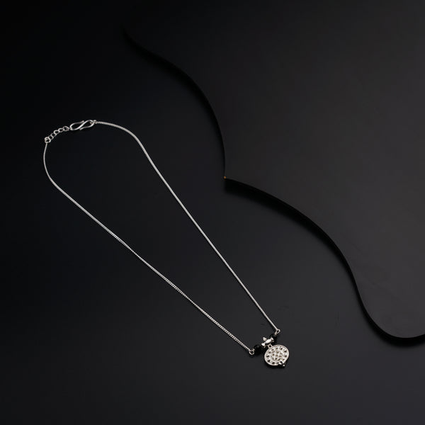a black and white photo of a necklace on a black background