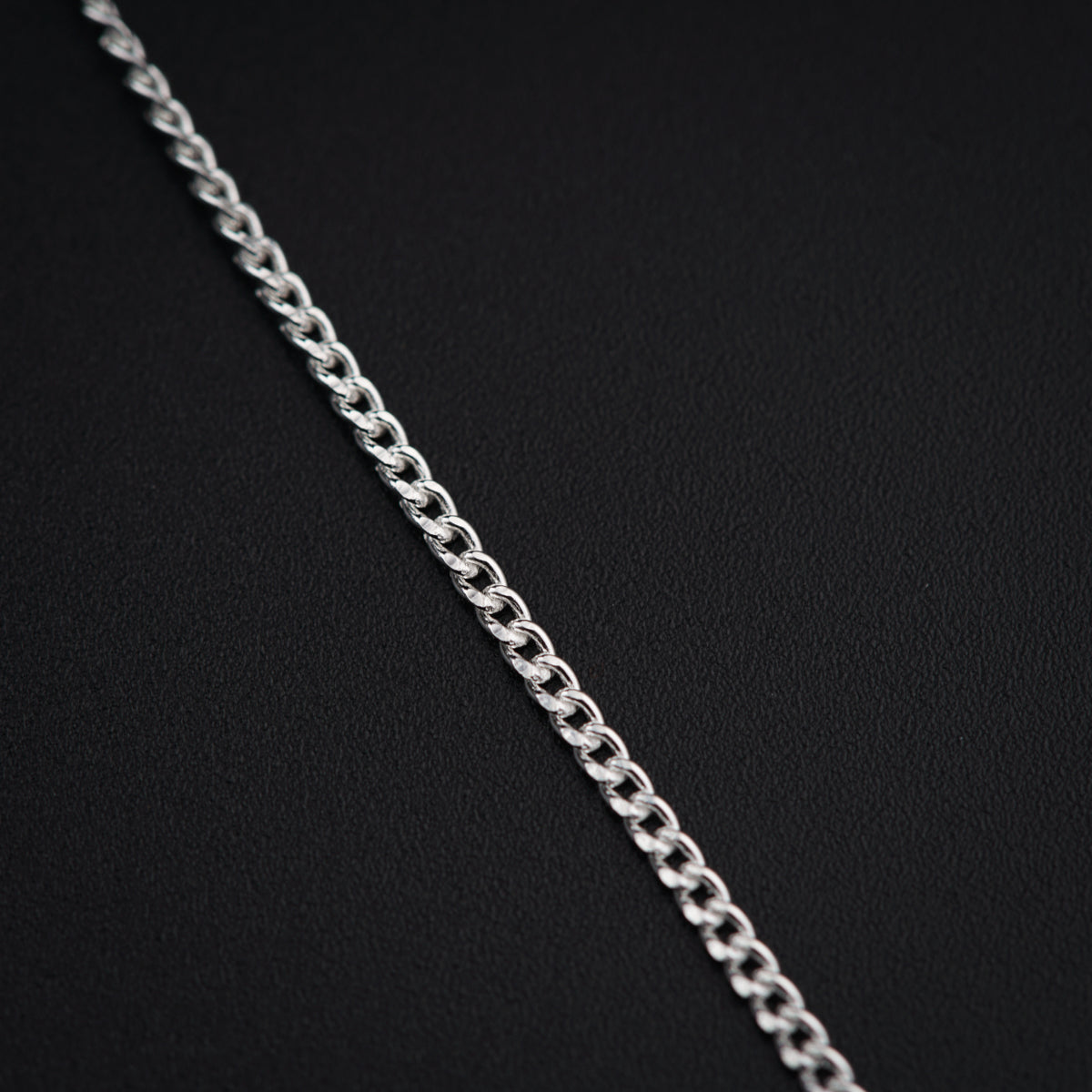 a close up of a chain on a black surface