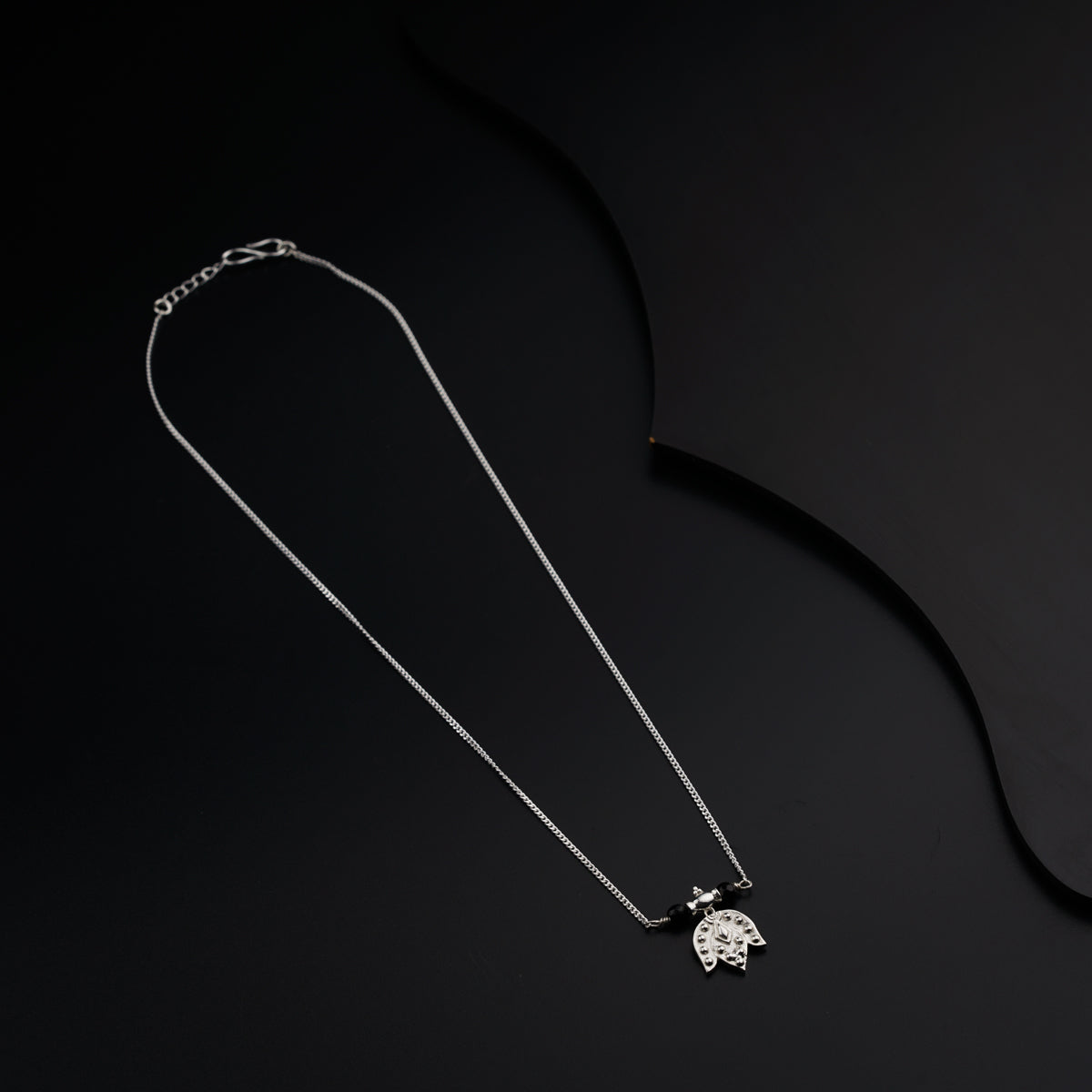 a necklace with a turtle pendant on a black background