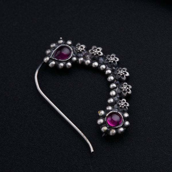 a close up of a piece of jewelry on a black surface