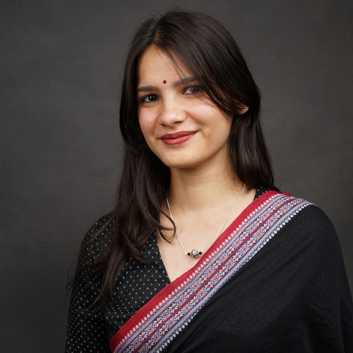 a woman in a black sari smiling at the camera