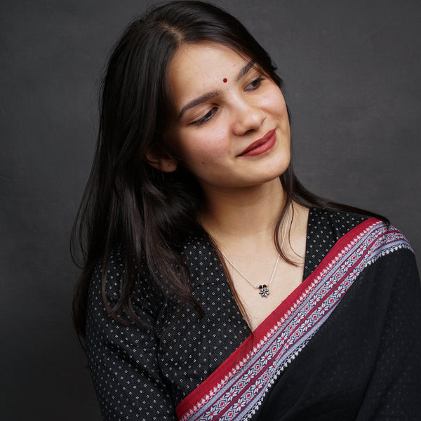a woman wearing a black and red sari