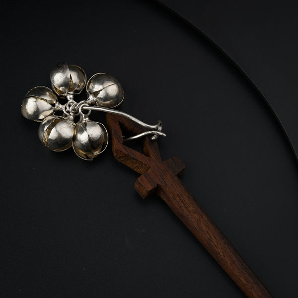 a metal object with a wooden handle on a black surface