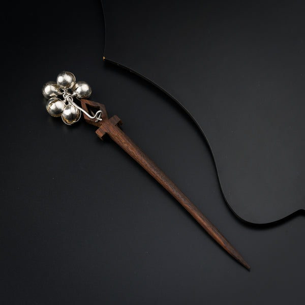 a metal object with a wooden handle on a black surface