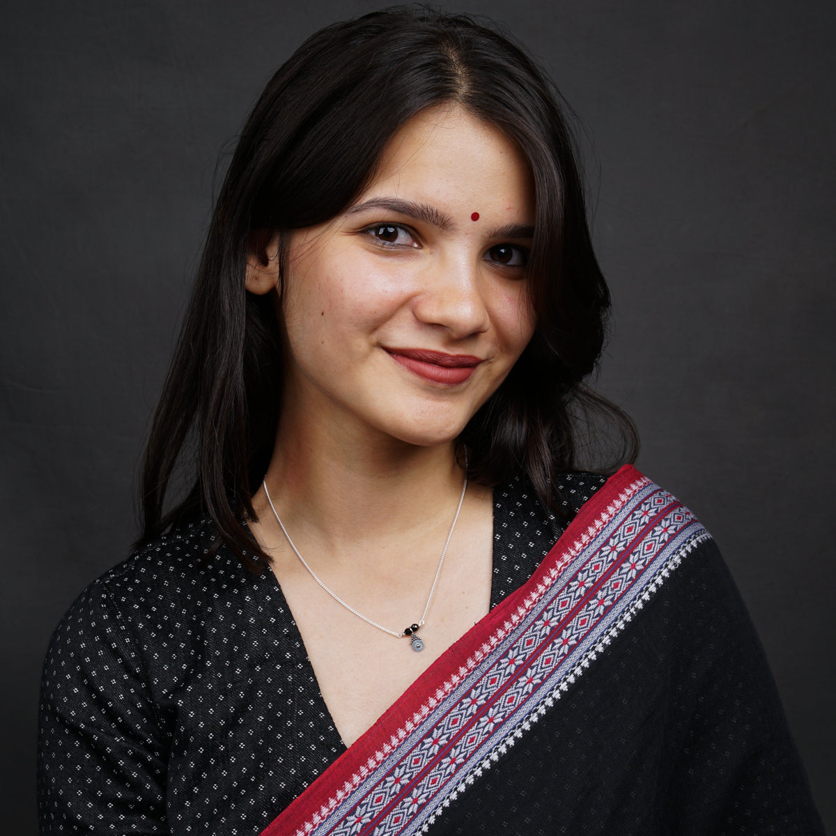 a woman wearing a black and red sari